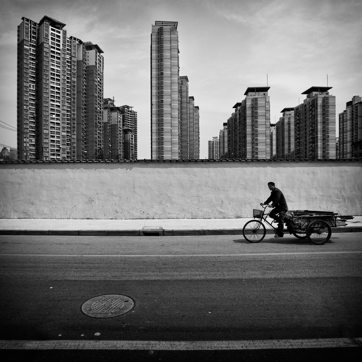 Mann auf Fahrrad vor Shanghai Skyline