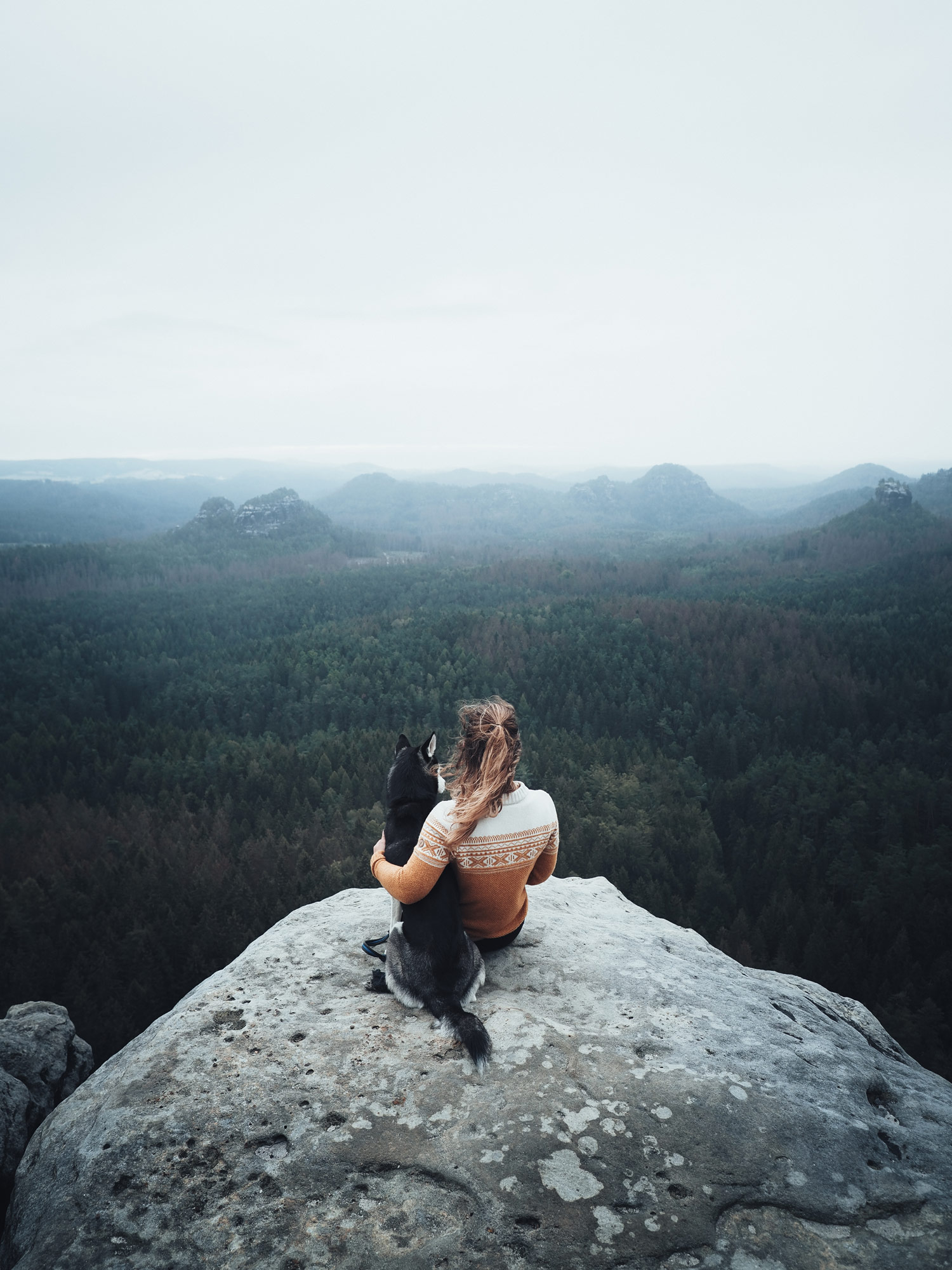 Frau mit Hund auf Fels