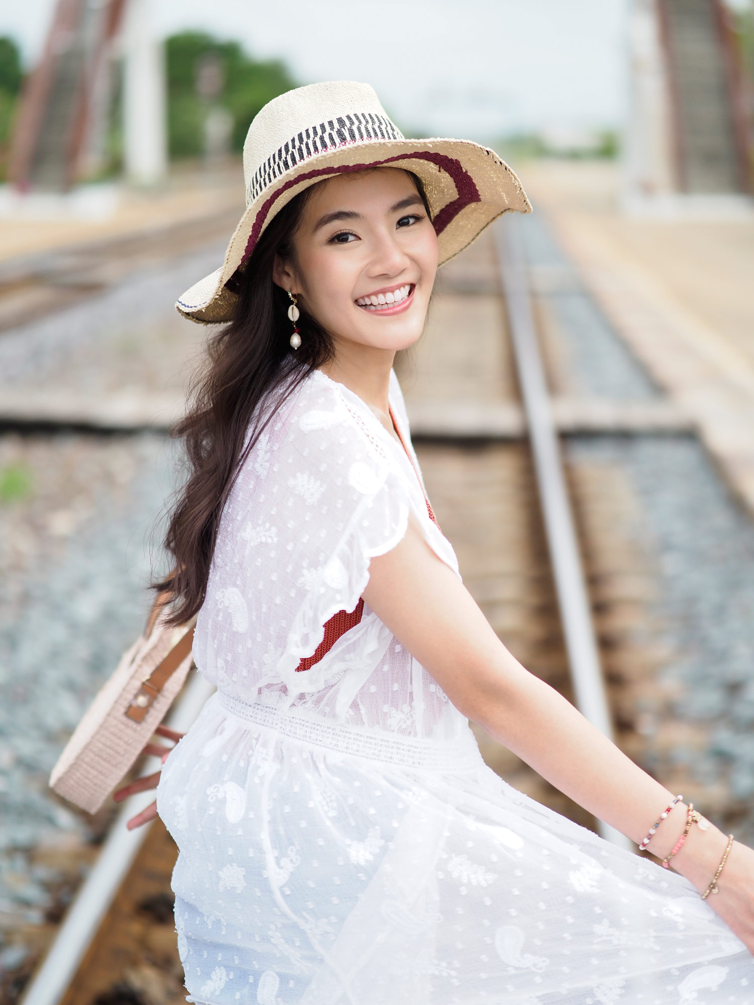 Frau mit Hut auf Bahngleisen